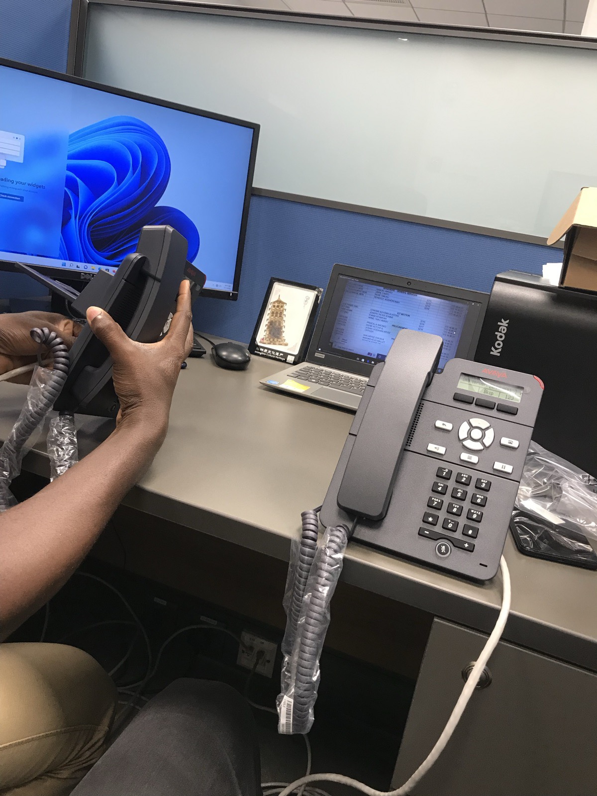 VoIP phone unboxing and setup at a desk